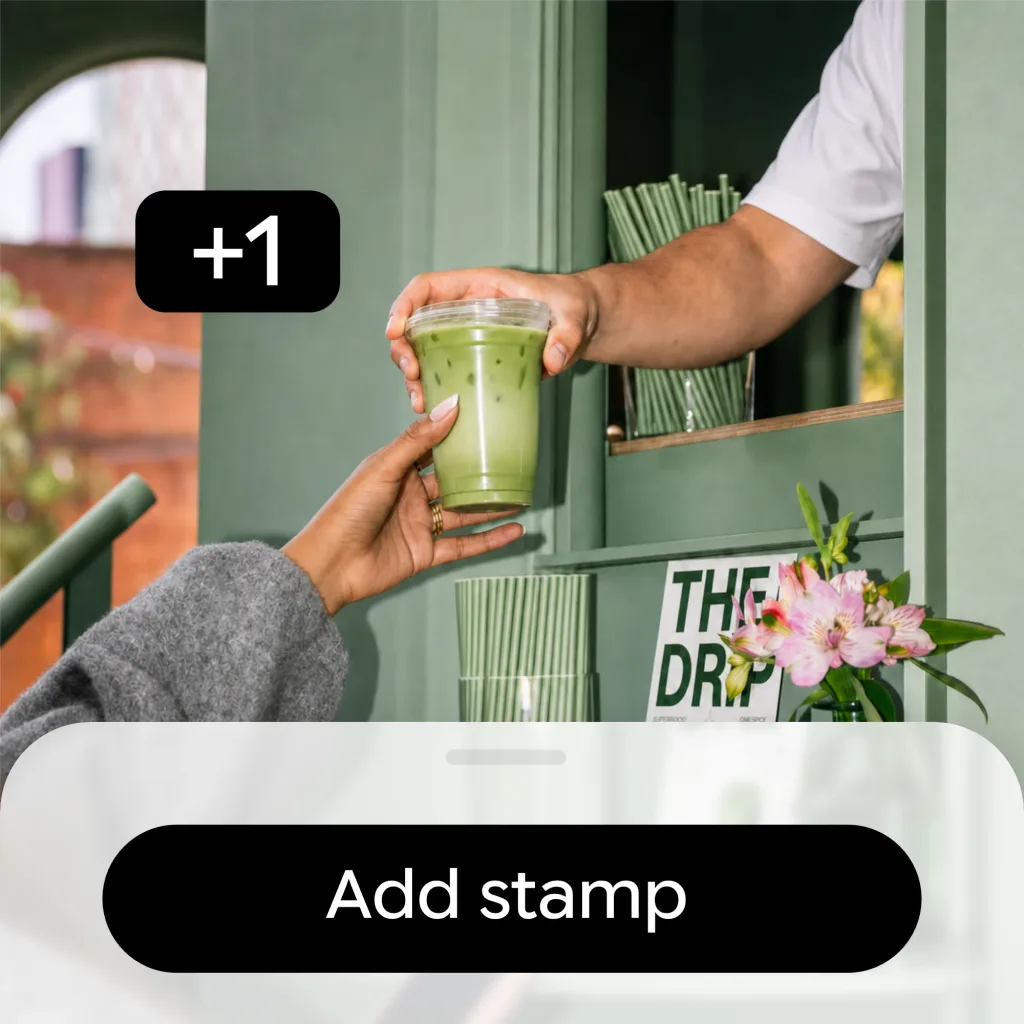 A drink handed over a café counter, with the Add stamp button and a +1 stamp